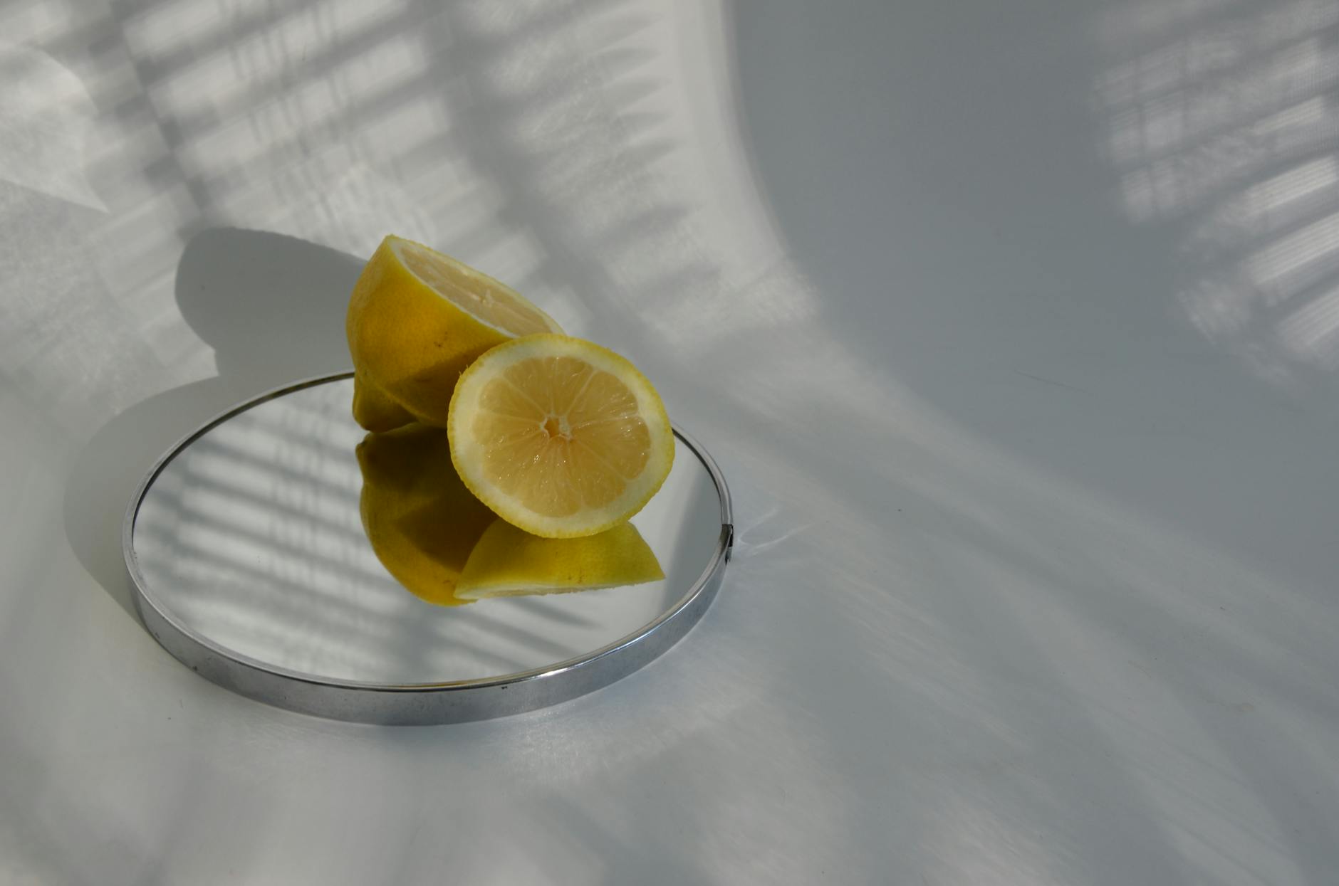 Hand holding a lemon on soft pink background, symbolizing reclaiming physical sensation and pleasure